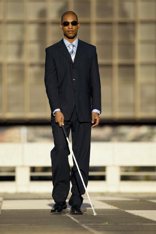 Man with a white cane wearing a suit